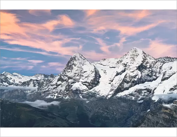Majestic mountains Eiger and Monch under pink clouds at sunset, Murren Birg