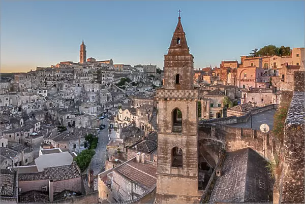 Sun rising over the canyon and Sassi di Matera old town with the campanile of the church of Saint Peter Barisano, UNESCO World Heritage Site, Matera, Basilicata, Italy, Europe
