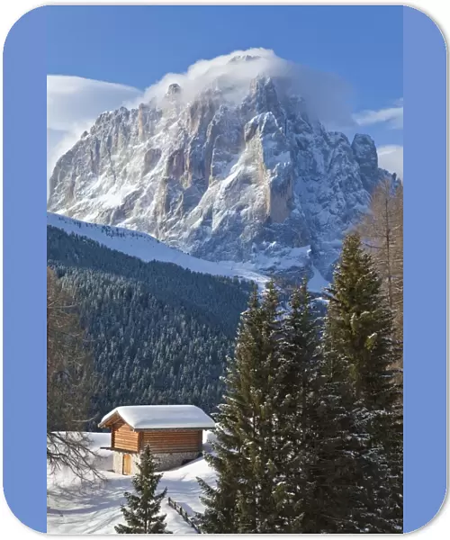 Winter snow covered mountain hut in front of Sassolungo mountain, 3181m