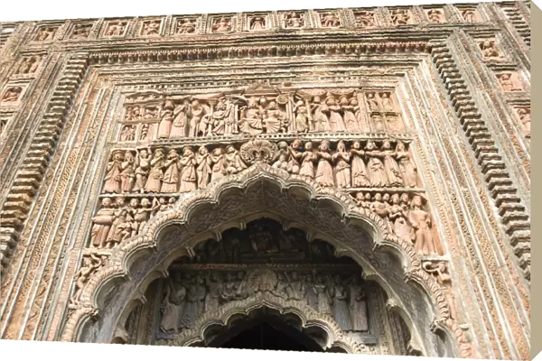 Ornate terracotta carvings of Hindu gods over the arched entrance to the Pratapeswar Temple