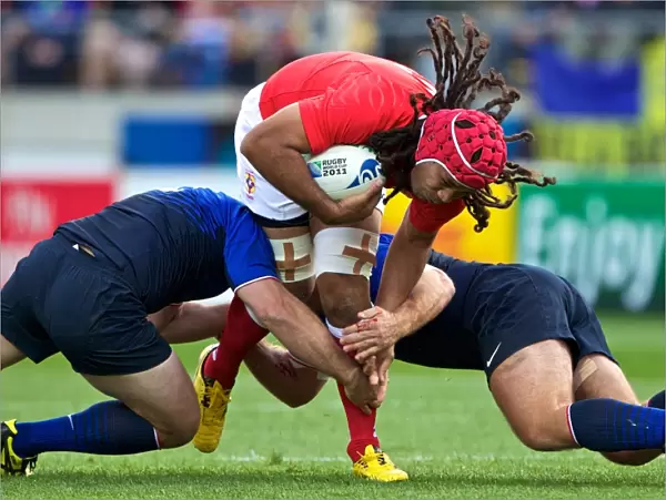 Tongas Paino Hehea is tackled by French defenders at the World Cup