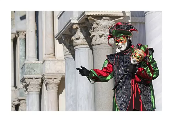 Man wearing a jester mask and costume at the Venice Carnival