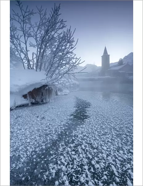 The frozen river Inn framed by mist and snow at dawn Sils Canton of Graubunden Engadine