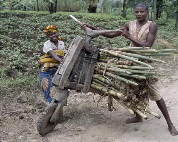 A young man and his wife push a homemade wooden bicycle