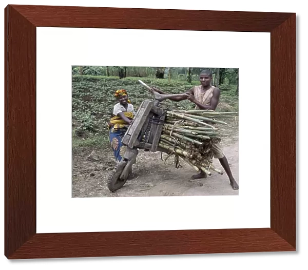 A young man and his wife push a homemade wooden bicycle