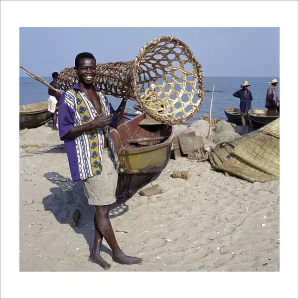 A young man carries a wicker fish trap
