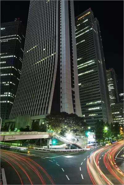 Car light trails under skyscrapers and city buildings
