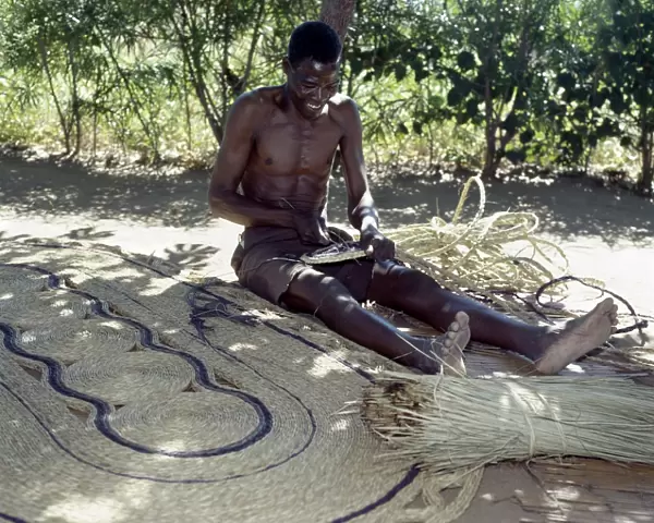 A man makes attractive floor mats from dried palm fronds near Liwonde