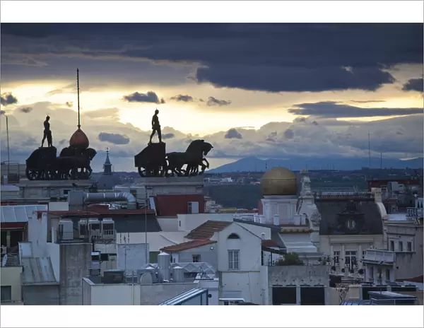 Spain, Madrid, elevated view of figures atop BBVA building, from the Circulo de Bellas