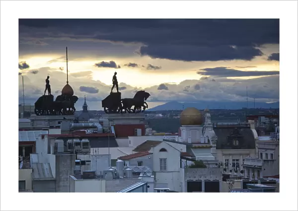 Spain, Madrid, elevated view of figures atop BBVA building, from the Circulo de Bellas