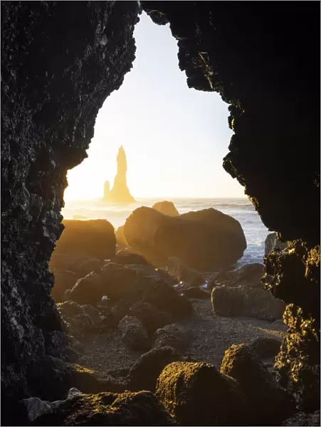 the stacks of Vik i Myrdal, seen from an hidden cave during a winter sunrise, Reynisfjara beach, southern Iceland