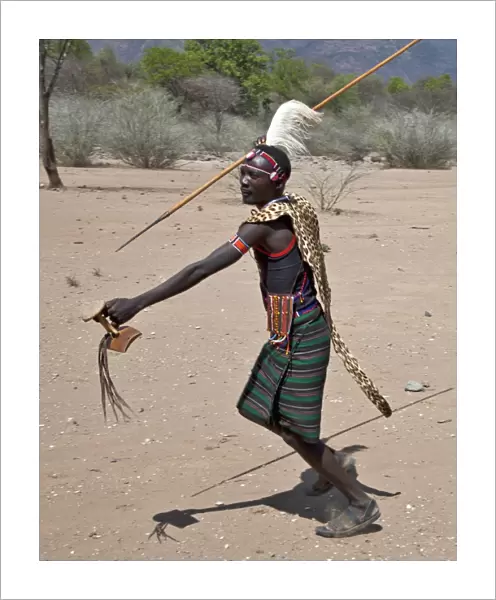 A Pokot warrior wearing a leopard skin cape celebrates an Atelo ceremony, spear in hand