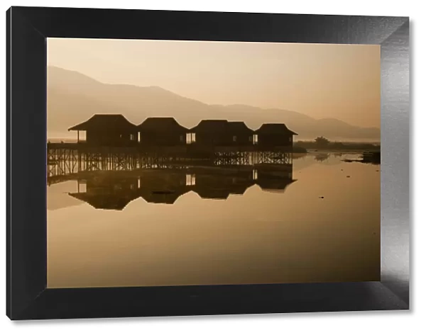 Myanmar, Inle Lake. A misty dawn at Golden Island Cottages, a resort for tourists owned by the Pa-O people, a collection of comfortable wooden huts on stilts