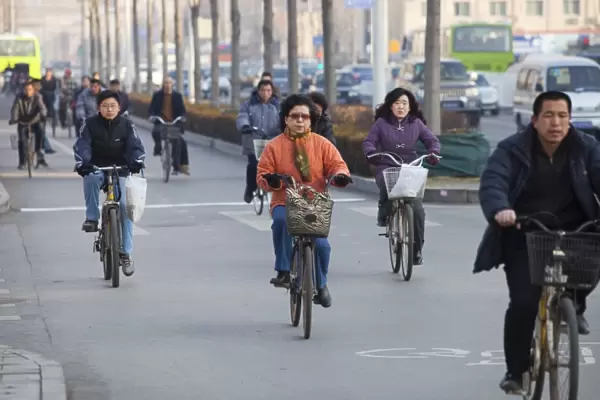 Cyclists and cars in Beijing. Increasinlgy the chinese as they become wealthier change from cycles to cars, a move that has been partly responsible for pushing china in 2008 into becoming the worlds largest emmitter of greenhouse
