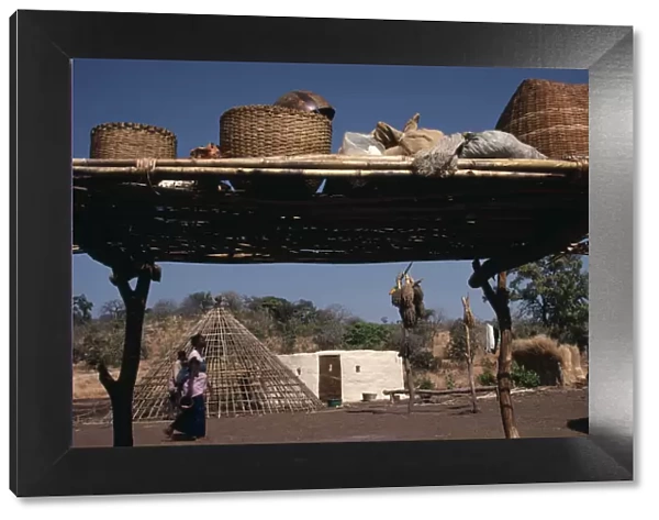 SENEGAL Family enclosure with circular hut beside frame of roof