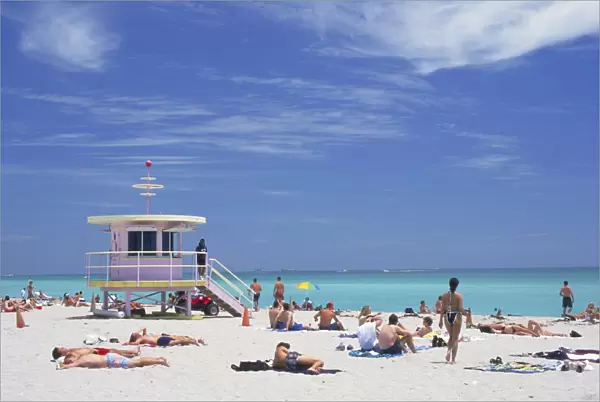 10065350. USA Florida Miami Sunbathers on the beach by a colourful lifeguard hut