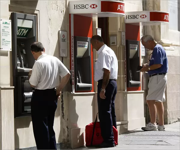 20090326. MALTA Valletta Three men using separate ATM cash machines on Republic Street