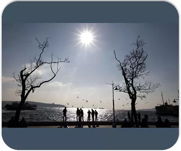 People enjoy sunny weather at a park by the Bosphorus in Istanbul