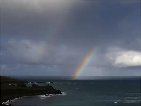 A rainbow forms as a squall moves towards Porthmeor Beach in St Ives in Cornwall