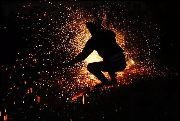 A Vietnamese man from the Pa Then minority group jumps into a fire during a ritual