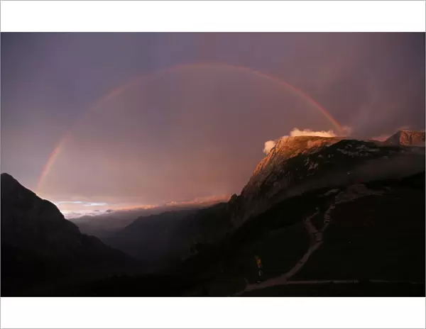 A rainbow spans over the Hohes Goell and Schneibstein mountains near the