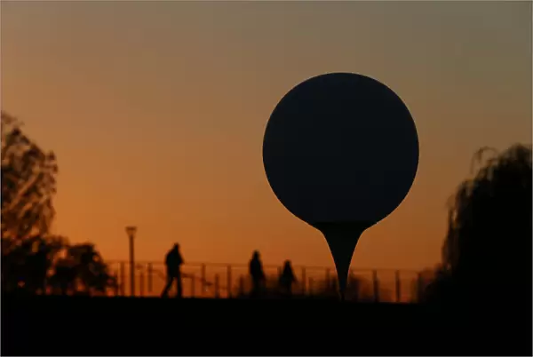 A balloon is silhouetted at sunset near the Spree river in Berlin