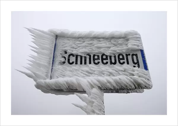 A village sign is covered with ice in Schneeberg