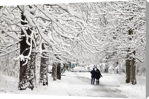 People walk on a snow-covered path in the Bois de Vincennes in Paris, France