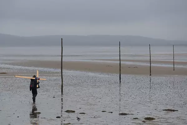 A pilgrim walks accross a tidal causeway on the final leg of the Northern Cross