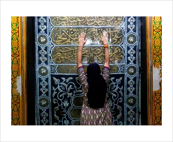 A woman prays at a shrine before breaking her fast during the holy month of Ramadan