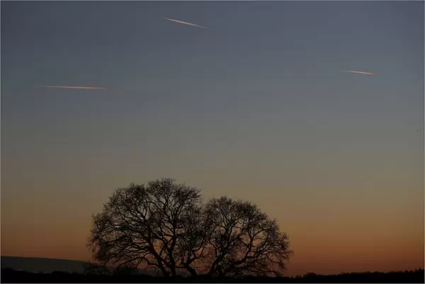 Passenger planes leave behind contrails as they fly in the skies over London Luton