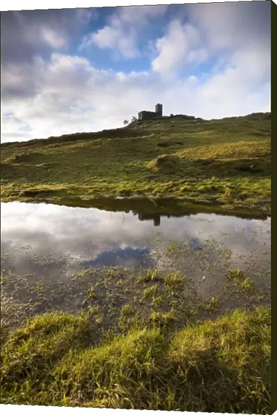 View of 13th century church reflected in large pool created by exceptional winter rain on moorland, Church of St