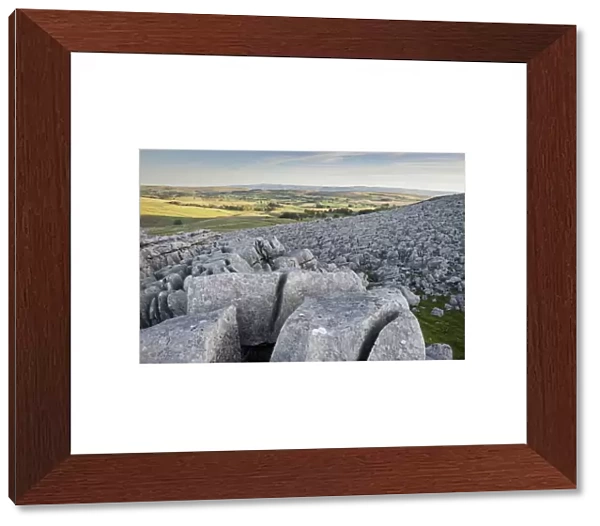 View of limestone pavement at sunrise, Fell End Clouds, looking towards Eden Valley, Cumbria, England, November