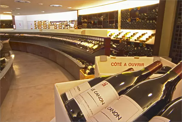 A curved display of bottles. In the foreground bottles of Le Canon SARL La Grande