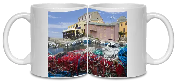 Corsica. France. Europe. Fishing nets stacked on dock at village of Centuri. Cap Corse