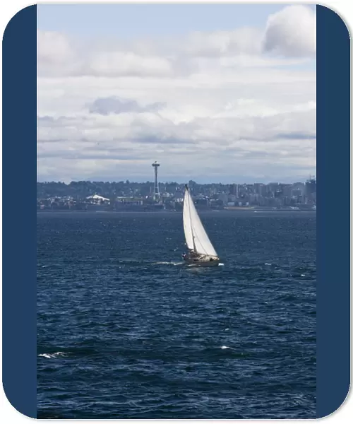 A small sailboat is propelled by a strong burst of wind off the coast of Seattle