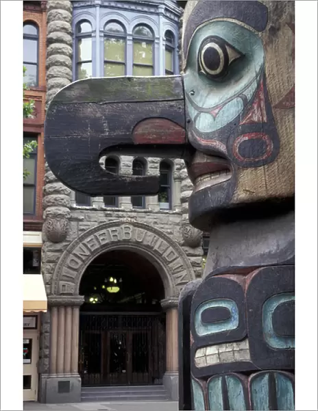 USA, Washington State, Seattle. Totem pole with Pioneer building in Pioneer Square