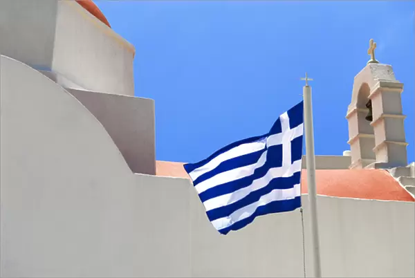Greece; Mykonos; Chora. The Greek flag flys over the Island of Mykonos