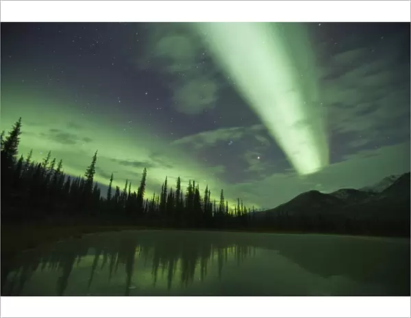 Streamers of bright green aurora borealis fill the north sky over the Brooks Range