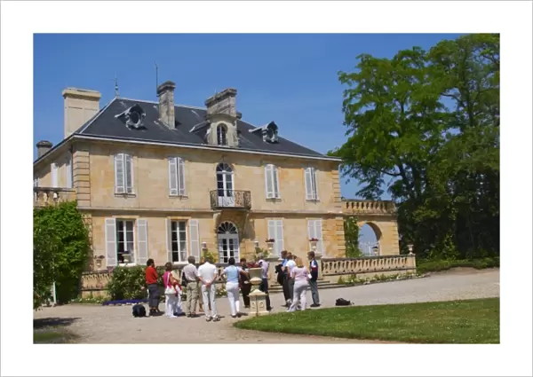 A group of visiting wine tasters in the garden in front of the chateau Chateau Kirwan