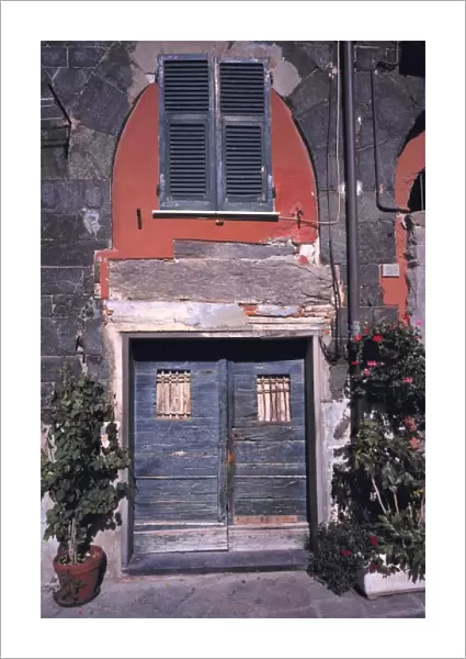 Europe, Italy, Vernazza. Blue wooden doors are accented by the red walls and ancient