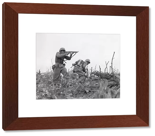 A U. S. Marine takes aim at a Japanese sniper near the town of Shuri, Okinawa, 1945