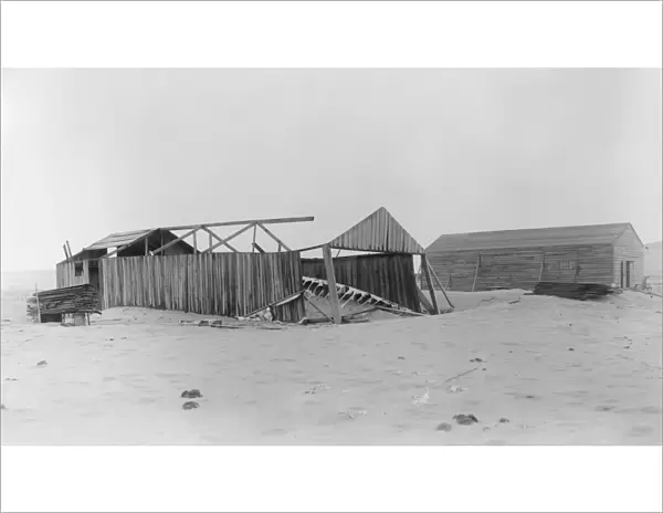 The camp at Kitty Hawk, North Carolina showing its damaged condition at the time of Wilburs arrival on April 10, 1908. The old 1902 building is on the left, its side walls still standing but its roof and north end gone. The remains of the 1902 glider are on the ground. Photograph by the Wright Brothers, 1908