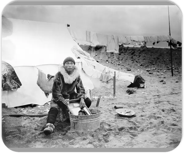 ALASKA: ESKIMO, c1906. An Inuit man doing laundry in tub outside his tent, with