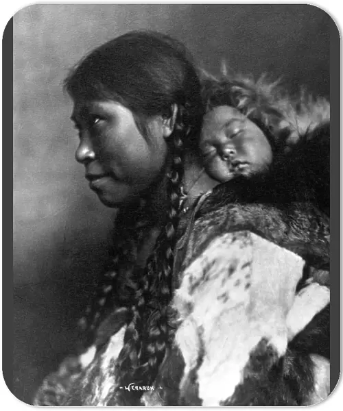 ALASKA: ESKIMOS, c1905. A mother carrying her sleeping child on her back, Nome, Alaska