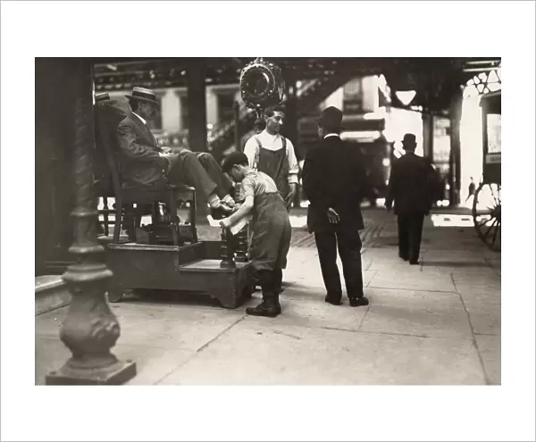 CHILD LABOR: BOOTBLACK, 1910. A young bootblack at work on 3rd Avenue and 9th Street
