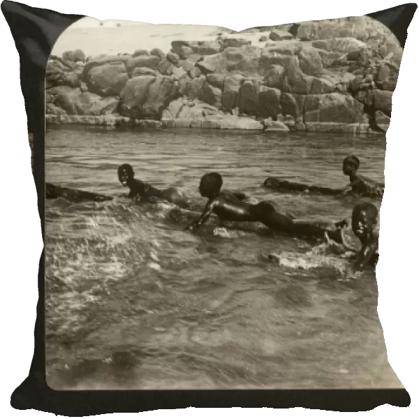EGYPT: NILE, 1901. Nubian boys shooting the rapids of the Nile on logs, Egypt