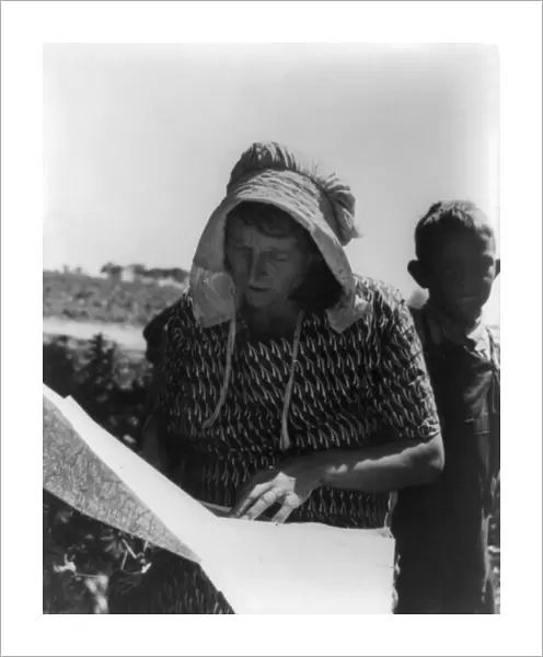 MIGRANT WORKER, 1935. Migrant women looking at a map for a route to California from Oklahoma