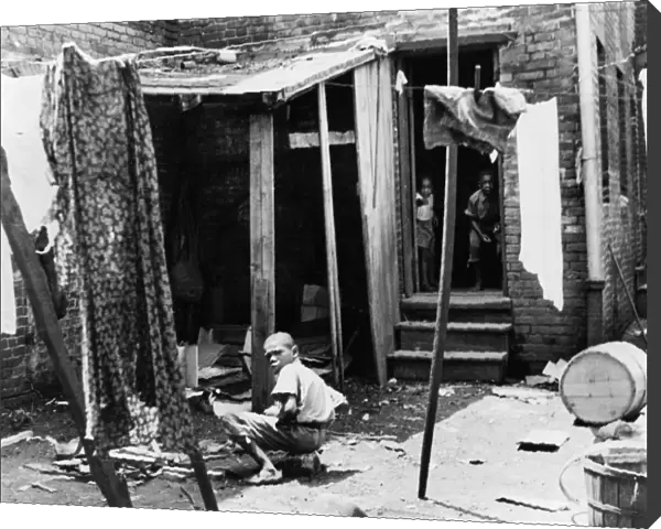 POVERTY: CHILDREN, 1935. Children in their backyard in the slum district of Washington, D