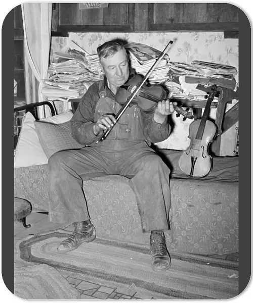 NEW MEXICO: MEN, 1940. George Hutton, a farmer from Maud, Oklahoma, playing his